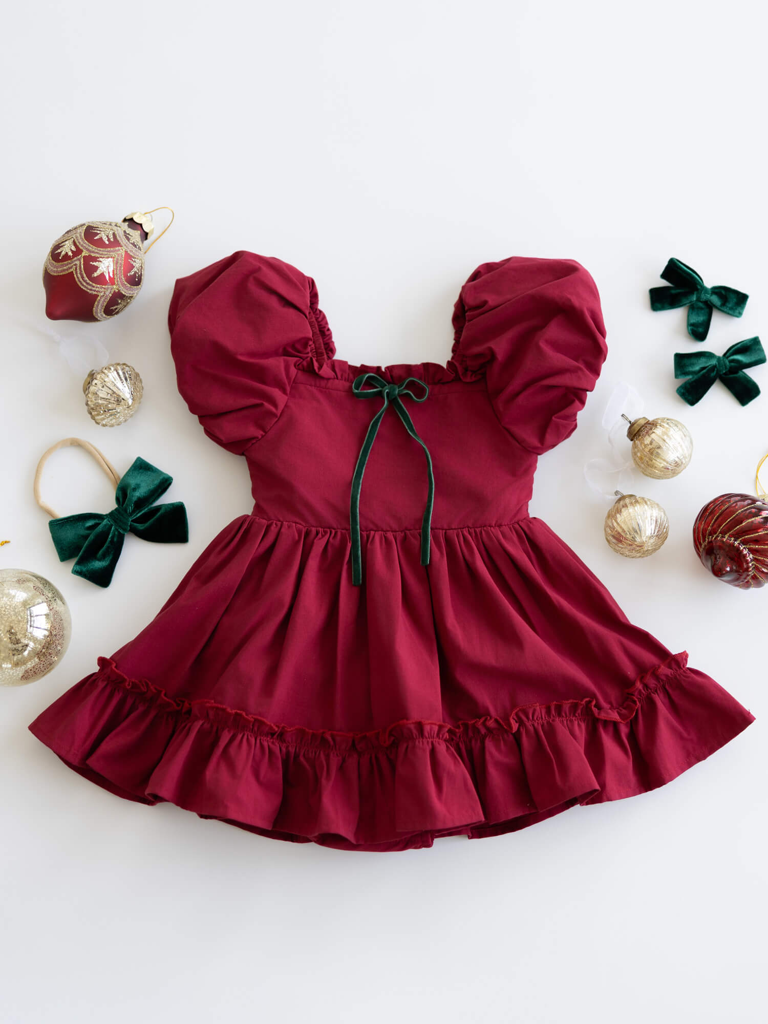Ava puff sleeve Christmas baby romper in crimson, with emerald velvet bow detail.