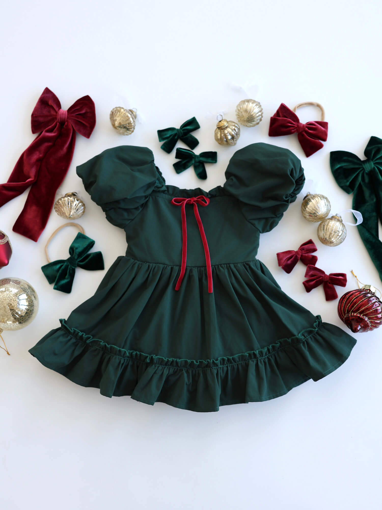 Ava emerald green baby Christmas romper with puff sleeves and crimson velvet bow.