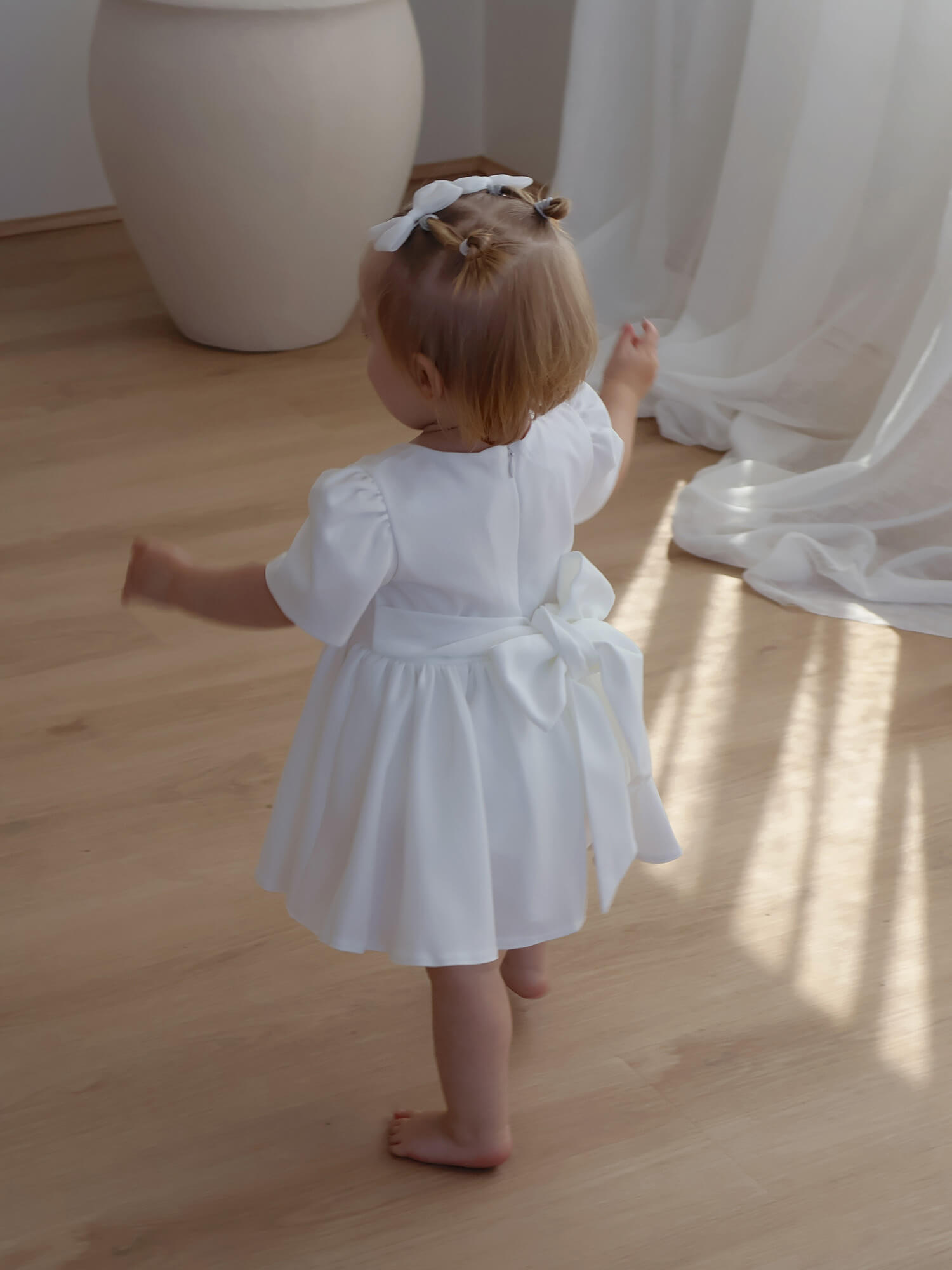 The back of our Charlotte ivory crepe flower girl dress showing the bow at the back.