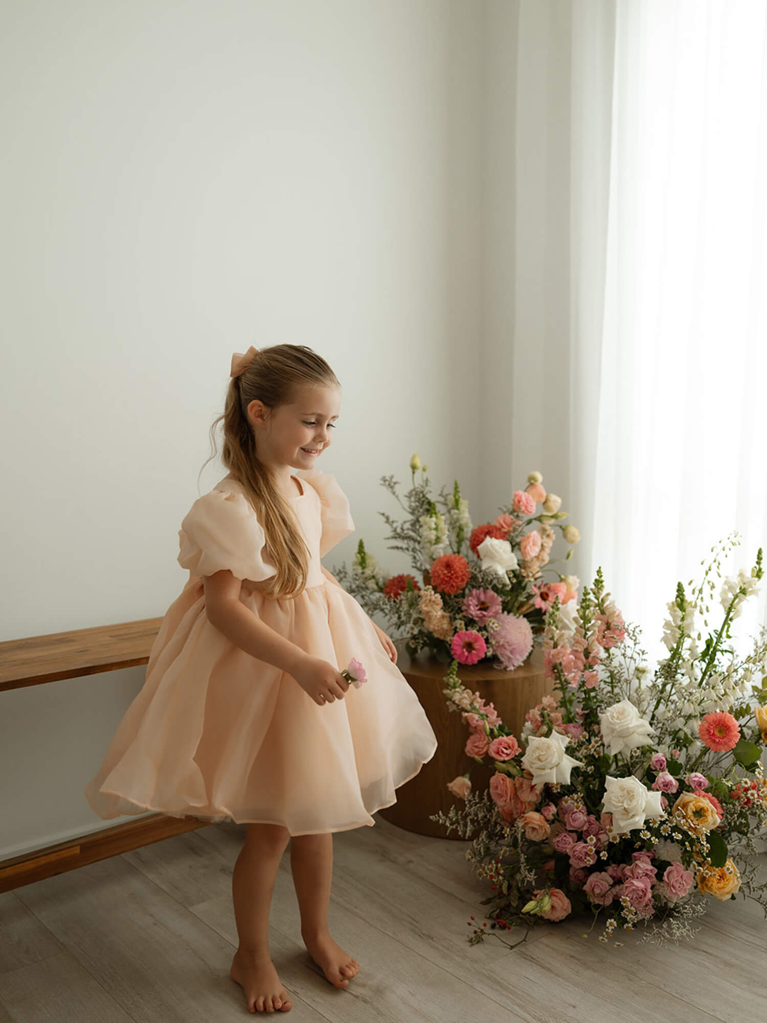 A young girl wears our Cleo champagne organza flower girl dress.