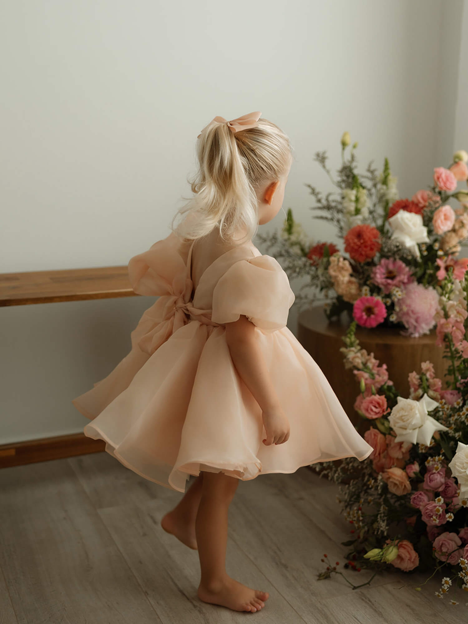 The back of our Cleo champagne organza baby flower girl gown. Showing the puff sleeves and back bow.