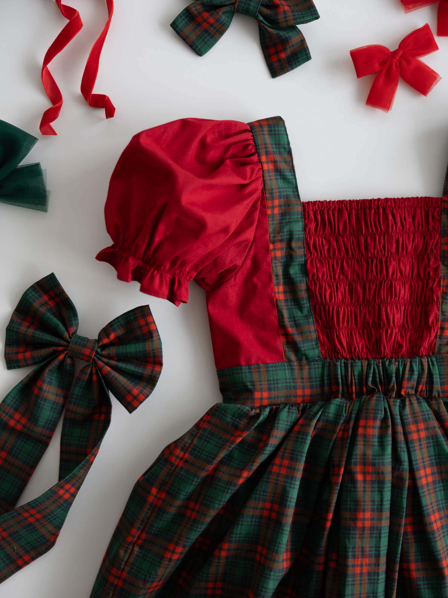 The back of our Ellie tartan baby romper, showing the shirring at the back and matching tartan accessories.