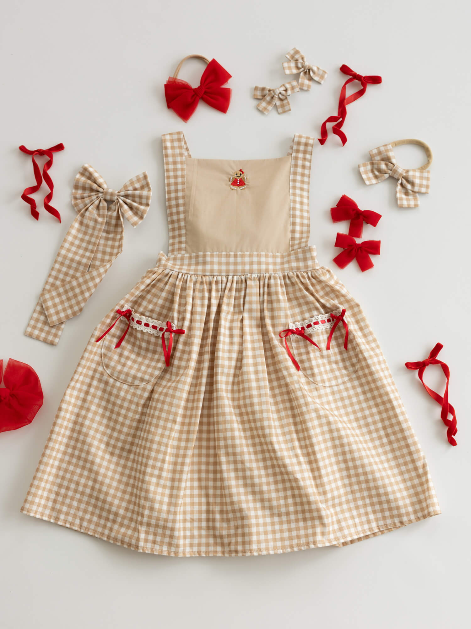 Children's beige plaid Christmas dress with Gingerbread man embroidery and red accents.