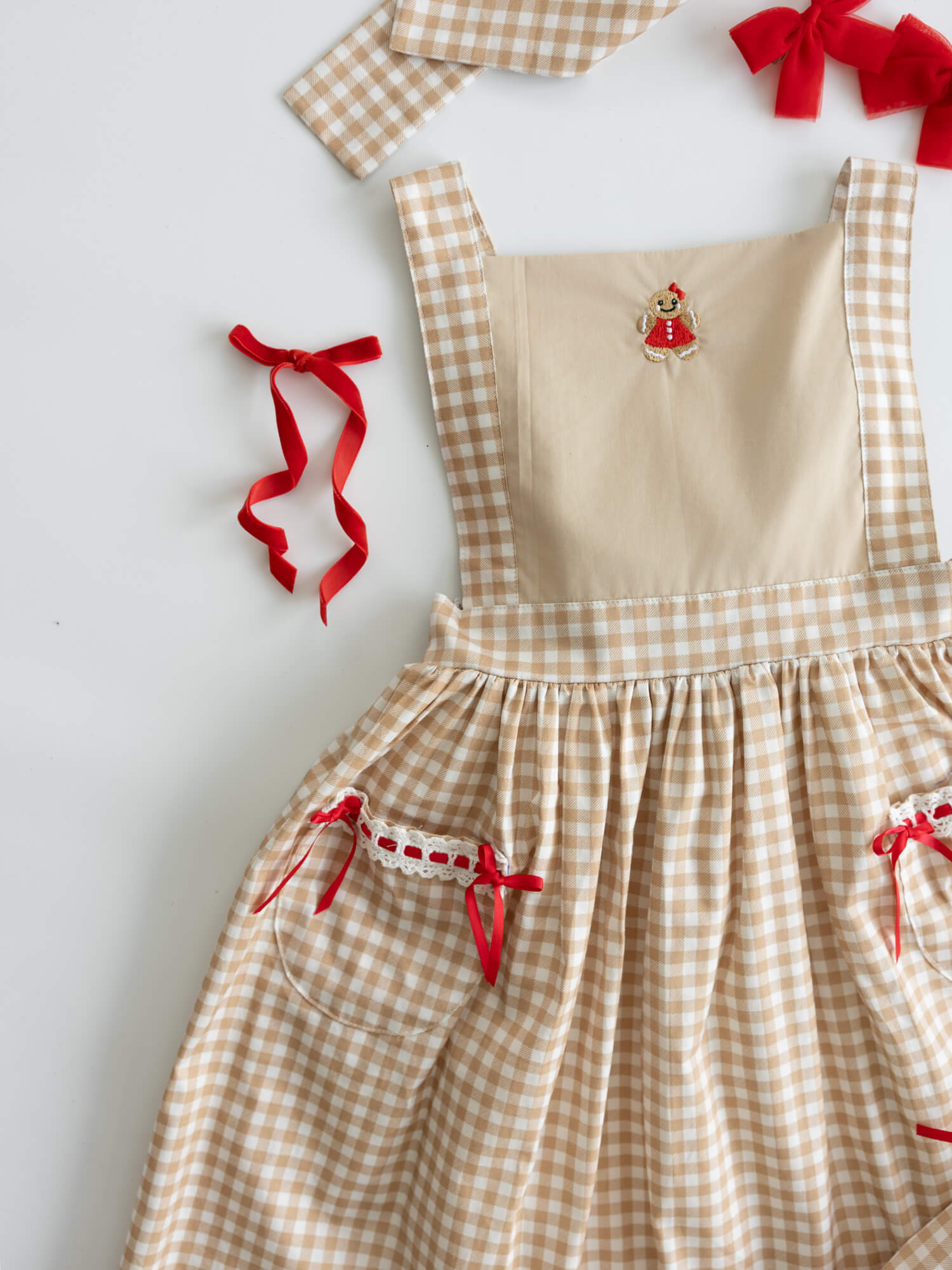 Ellie Gingerbread plaid Christmas dress with embroidery and red bow accents.