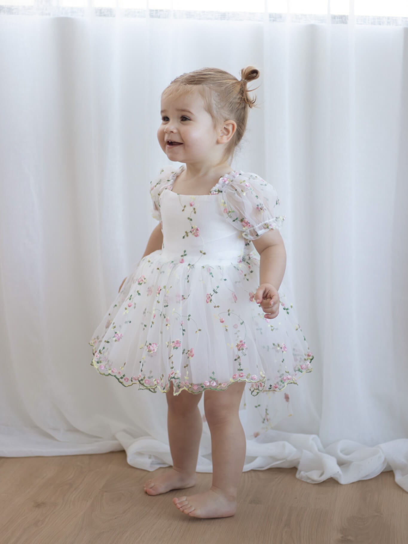 Fleur meadow flower girl romper dress is worn by a toddler.