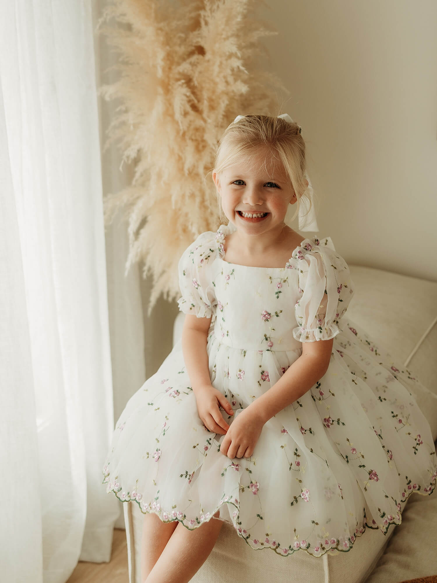 A young girl wears our lilac fleur flower girl dress with purple embroidered organza floral.
