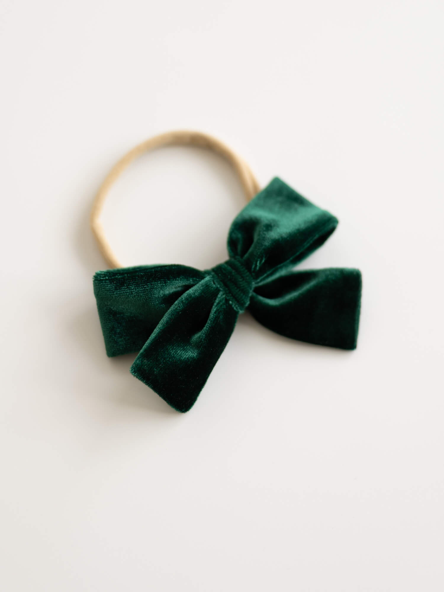 Green velvet Christmas hair bow on a headband for babies and toddlers.
