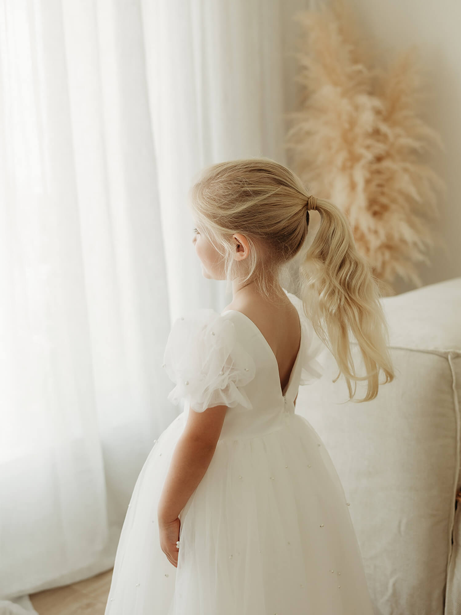 Gracie beaded tulle puff sleeve flower girl dress is shown on a young girl.