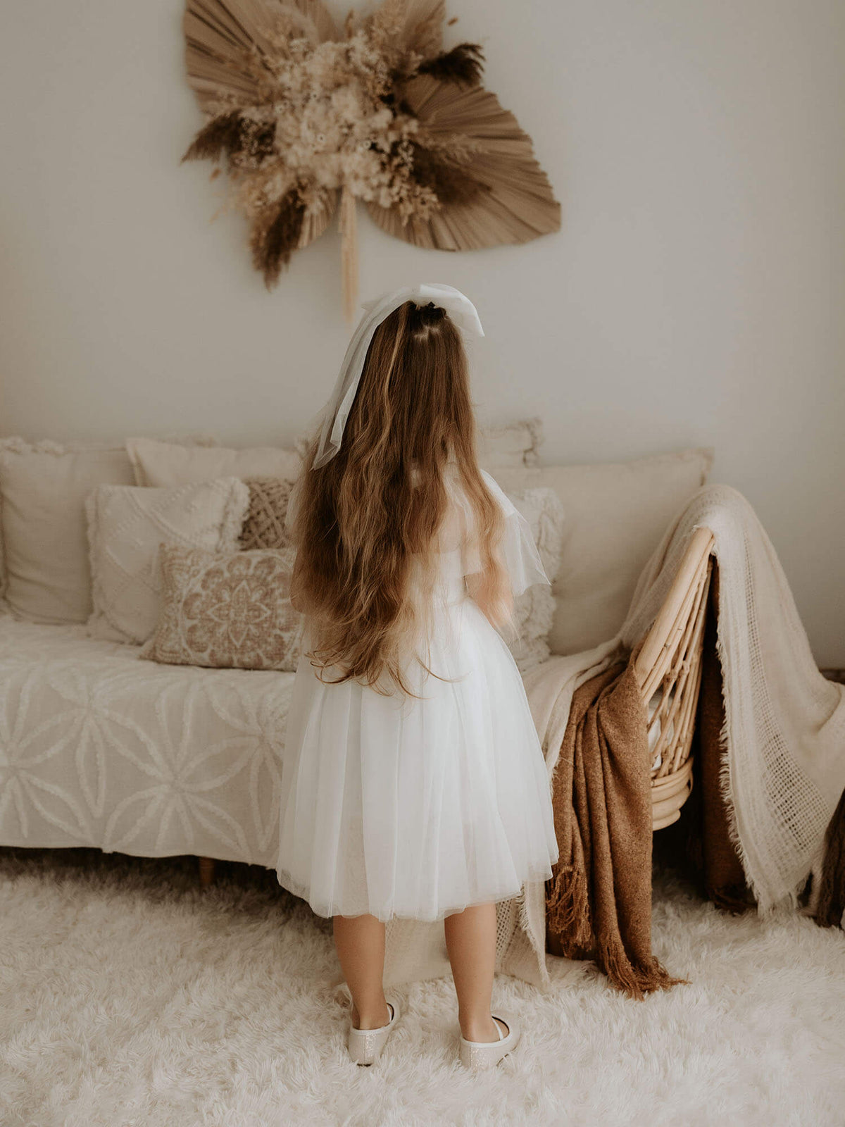 Our Isla flower girl dress in ivory shown from the back.
