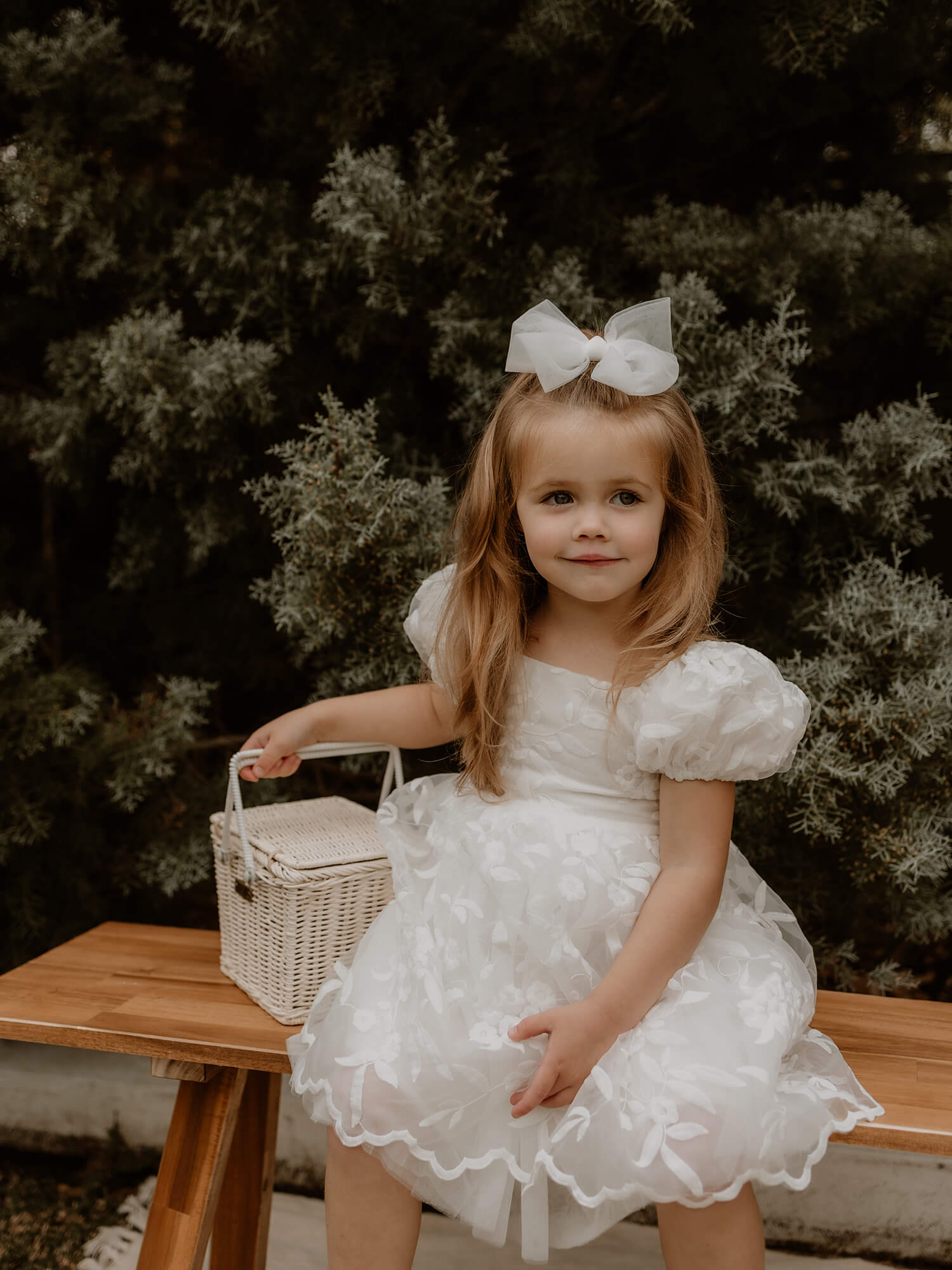Kenzi flower girl dress with lace puff sleeves is worn by a flower girl.