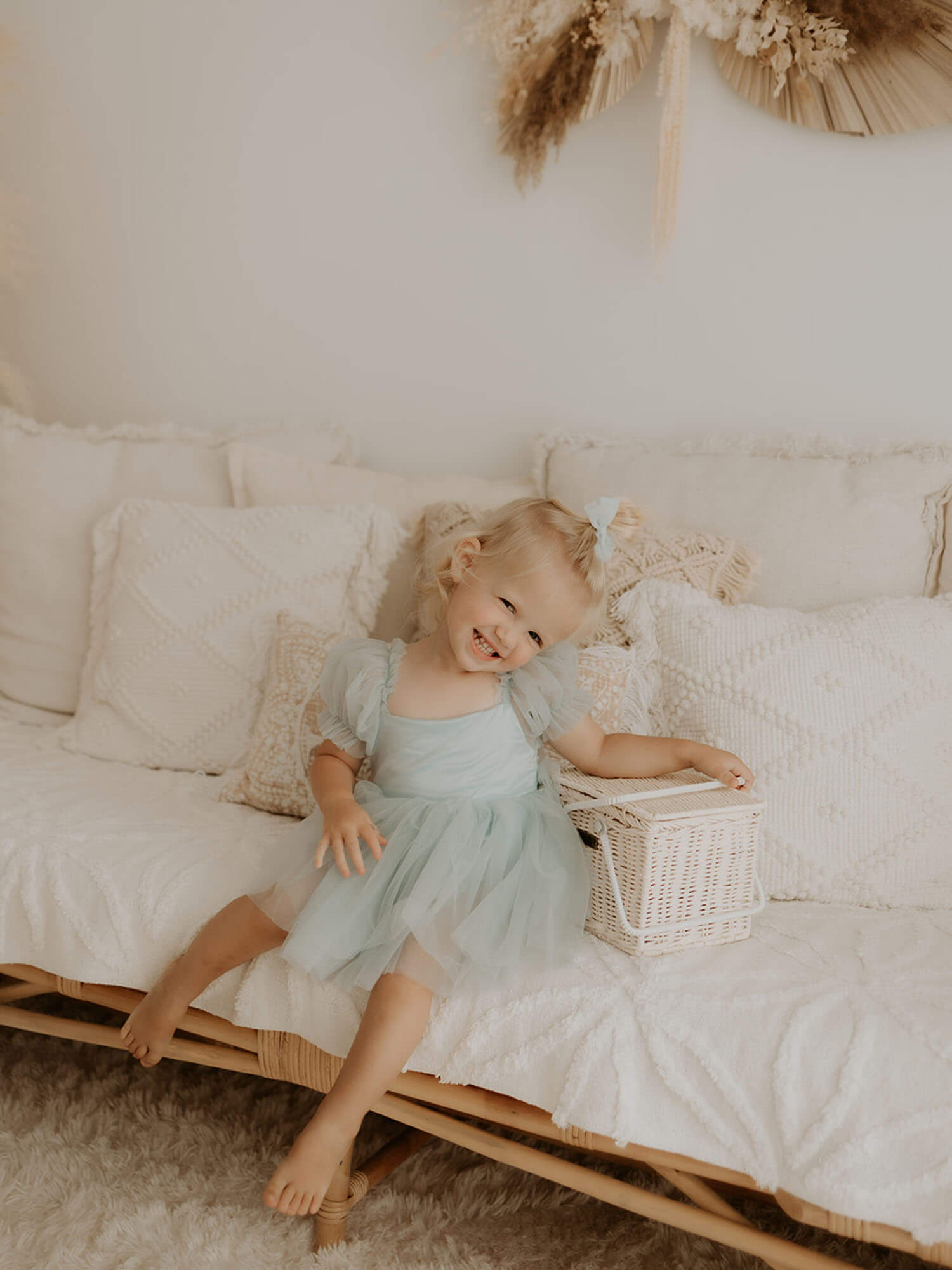 Layla dusty blue baby girl romper is worn by a young girl. She also wears a tulle pigtail bow in her hair.