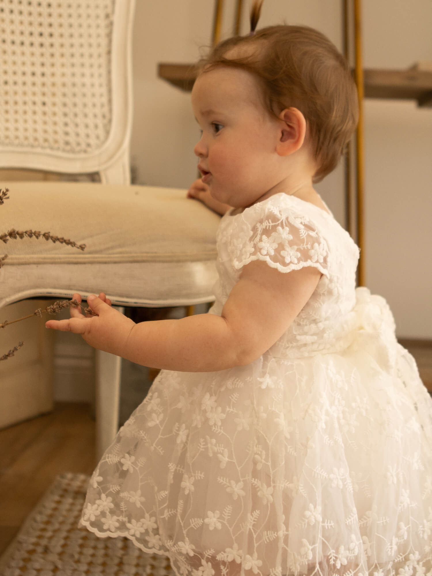 Pippa floral lace baby romper is worn by a little girl.