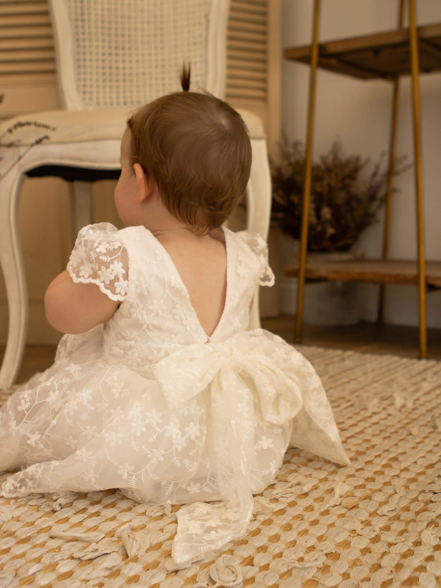 Pippa baby flower girl dress in floral lace is worn by a little girl.