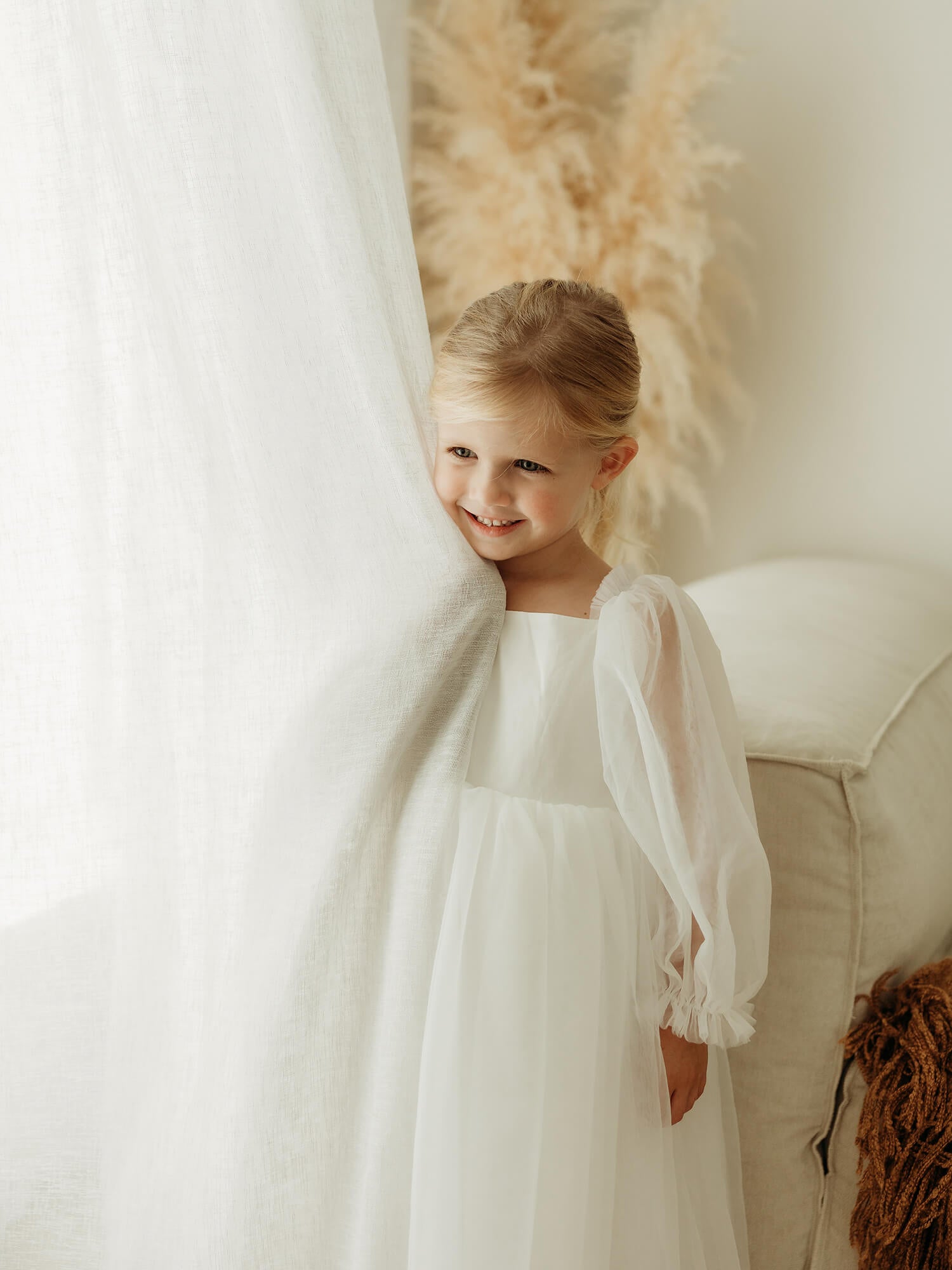 Wren ivory tulle flower girl dress is worn by a young girl.