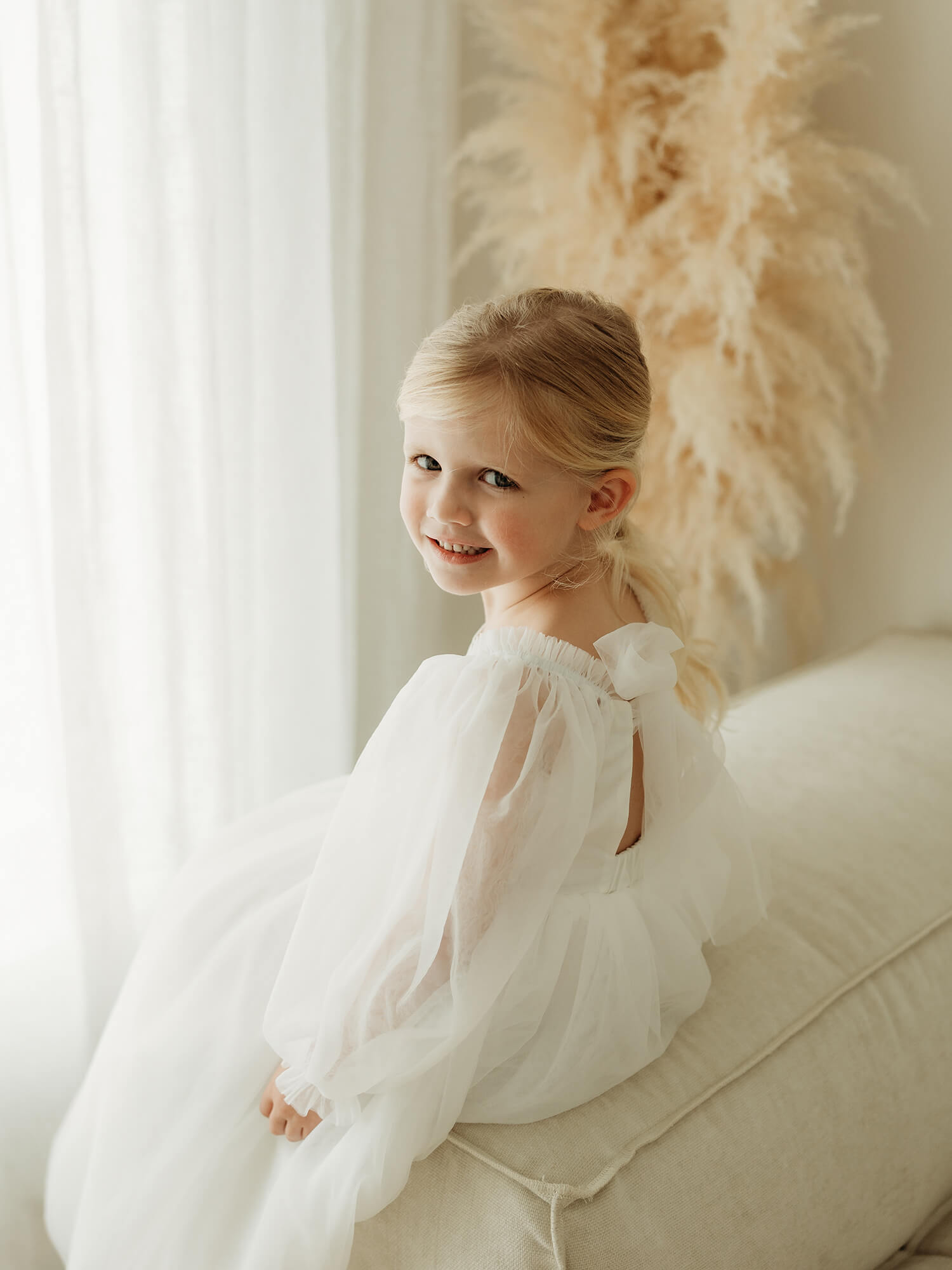 Full length tulle sleeves and tulle bow at the back of our Wren flower girl dress.