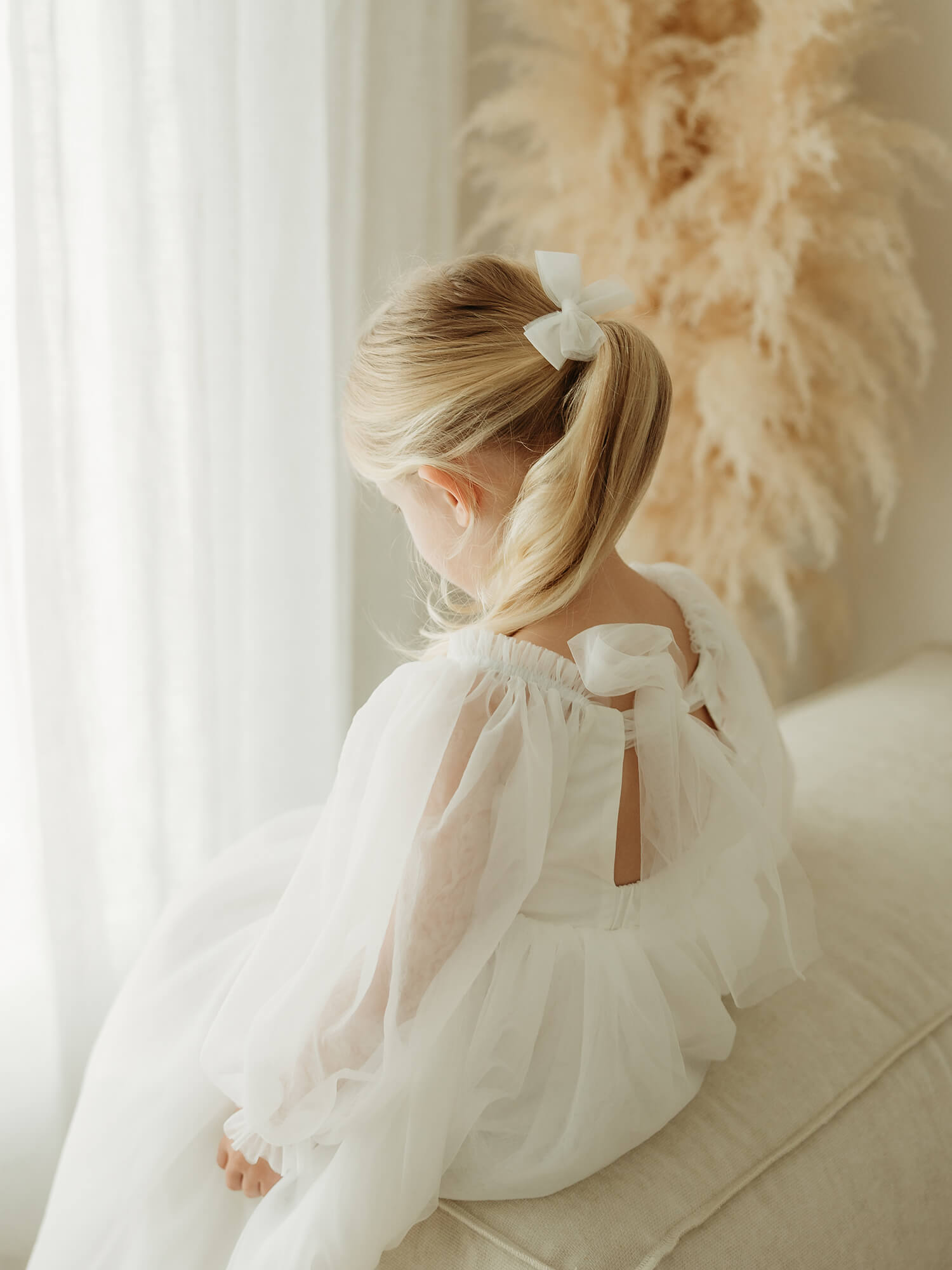 Ivory tulle flower girl dress with tulle bow at the back.