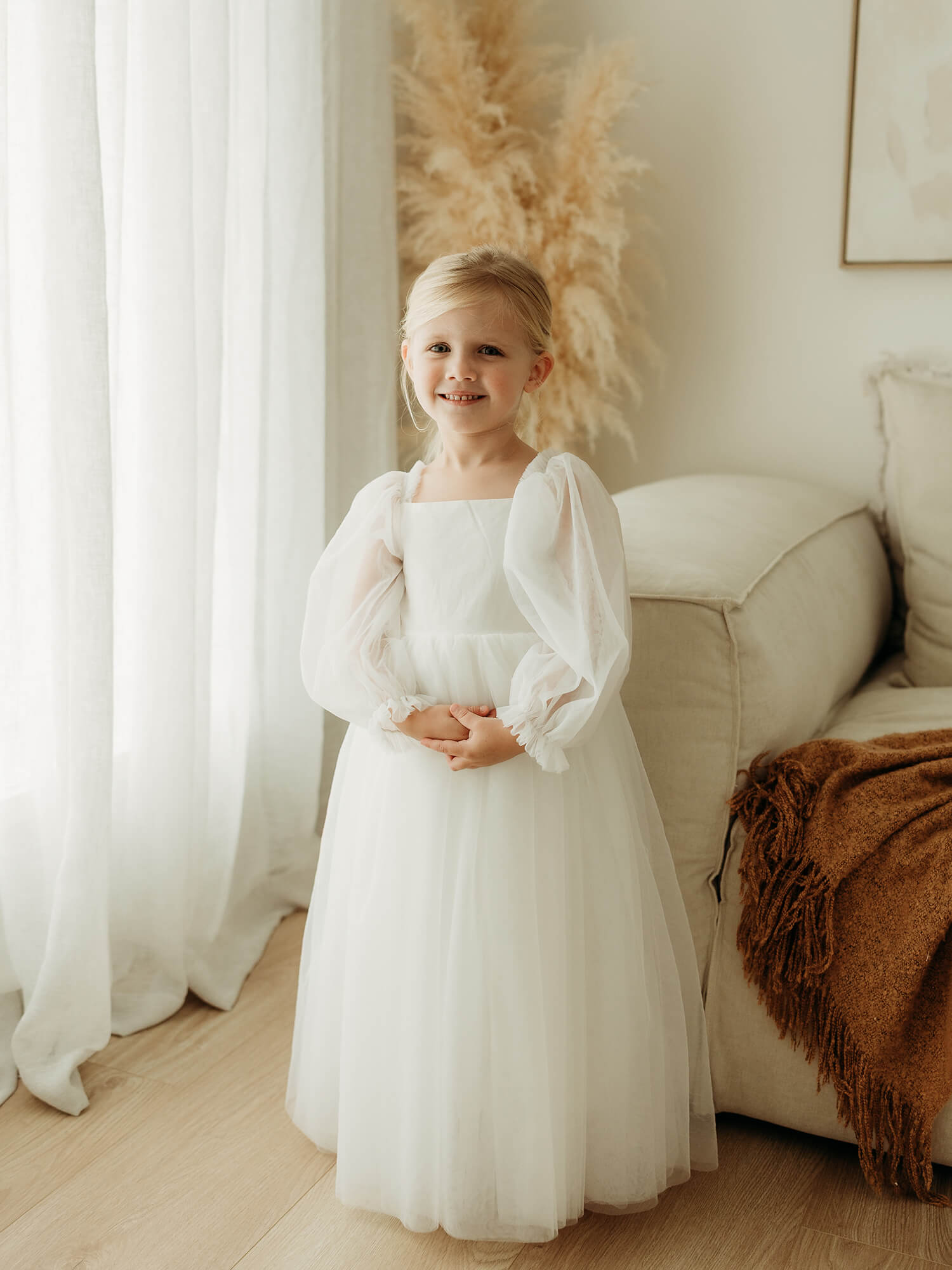 Young girl in white Wren full length flower girl dress.
