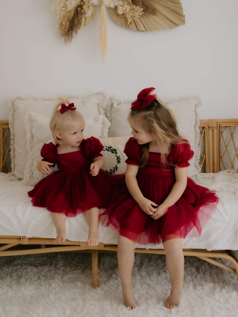 Sisters wear our Layla Christmas dress & romper in crimson.