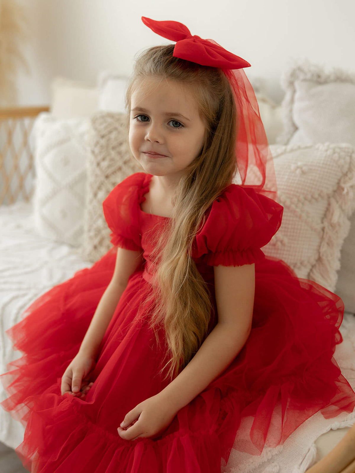 Ruby red tulle flower girl dress & Christmas dress, Gabrielle dress, is worn by a young girl.