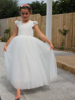 Abigail white flower girl dress shown from the front. Showing full length soft tulle skirt & lace flutter sleeves.