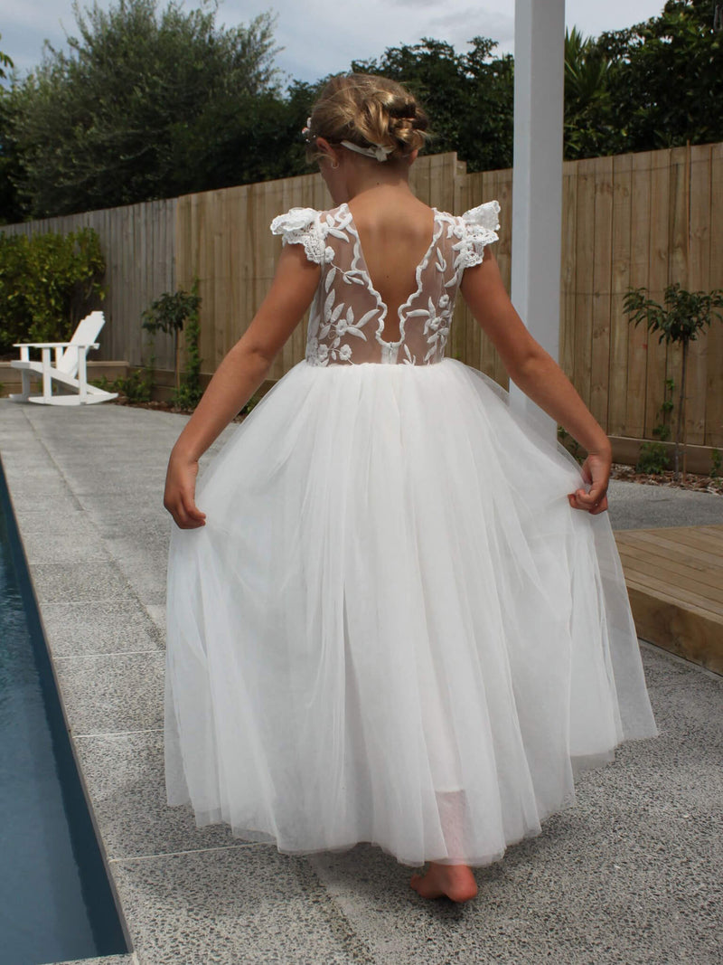 Abigail flower girl dress worn by a young girl. Showing feature lace back and full length tulle skirt.