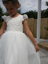 Abigail white flower girl dress worn by a young girl.