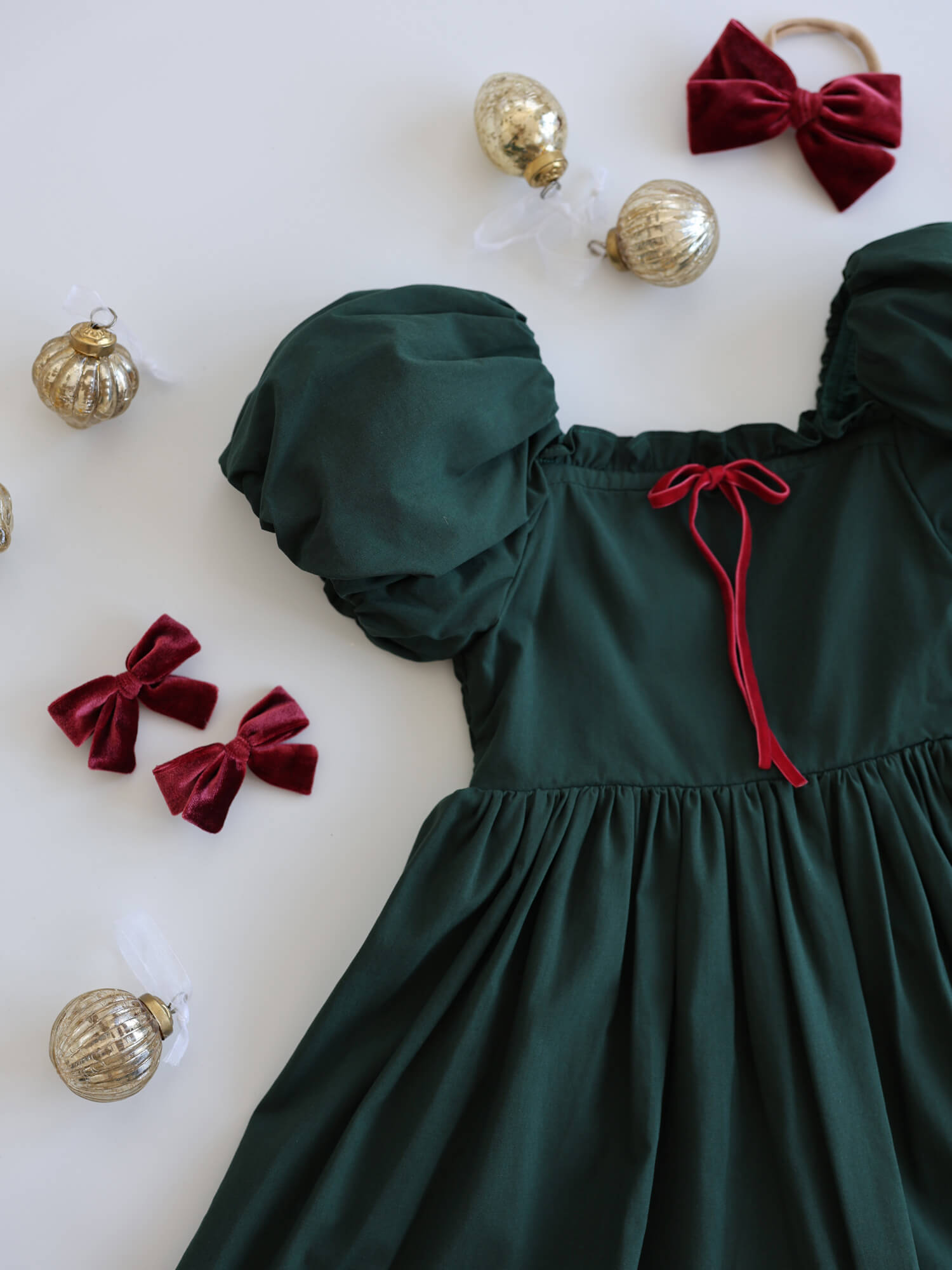 Ava emerald green Christmas dress with crimson velvet bow detail at the neckline.