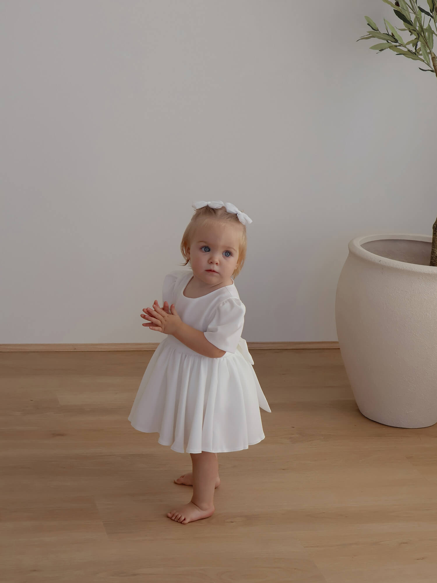 Ivory Charlotte crepe baby flower girl dress is worn by a toddler.