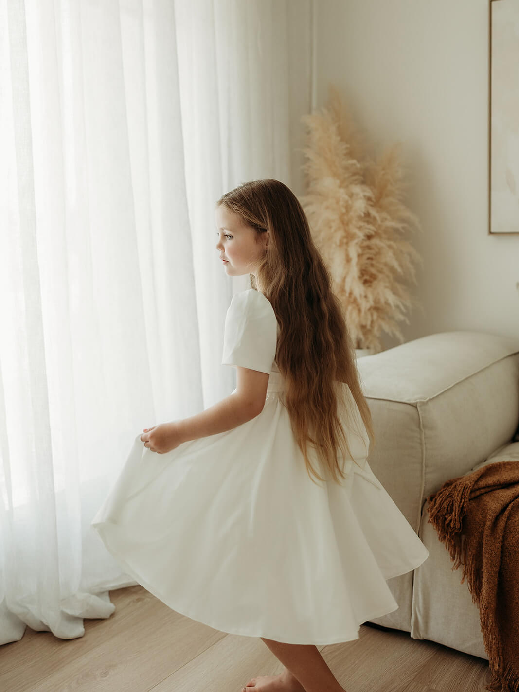 A little girl twirls wearing our Charlotte crepe flower girl dress.