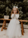Chloe ivory flower girl cover up cardigan is worn by a young girl, along with a tulle flower girl dress.