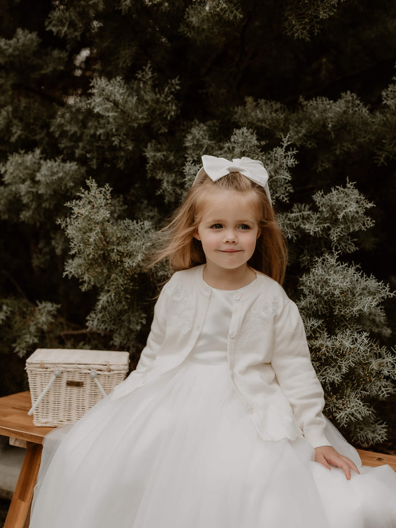 Chloe flower girl cover up is worn by a young girl.