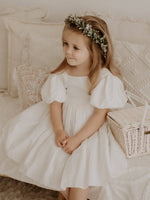 Cleo linen flower girl dress and Blythe flower crown worn by a young flower girl.