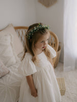 A young girl wears our Cleo linen puff sleeve flower girl dress and Blythe flower crown.