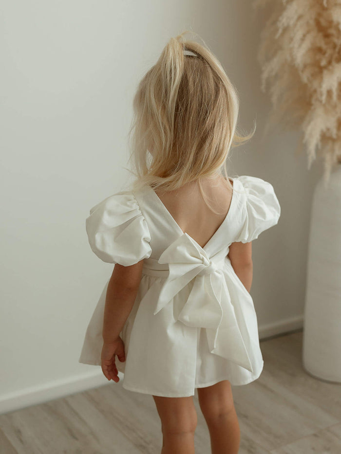 The back of our Cleo linen baby flower girl romper, showing the bow at the back.