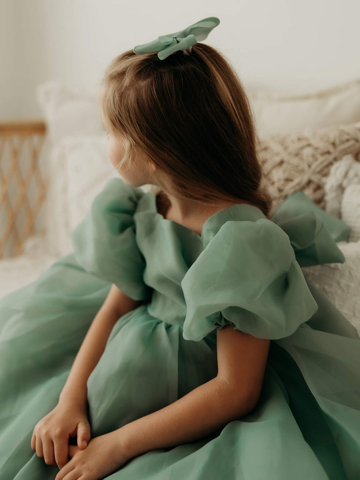 Cleo puff sleeve flower girl dress in Jade green is worn by a young girl.