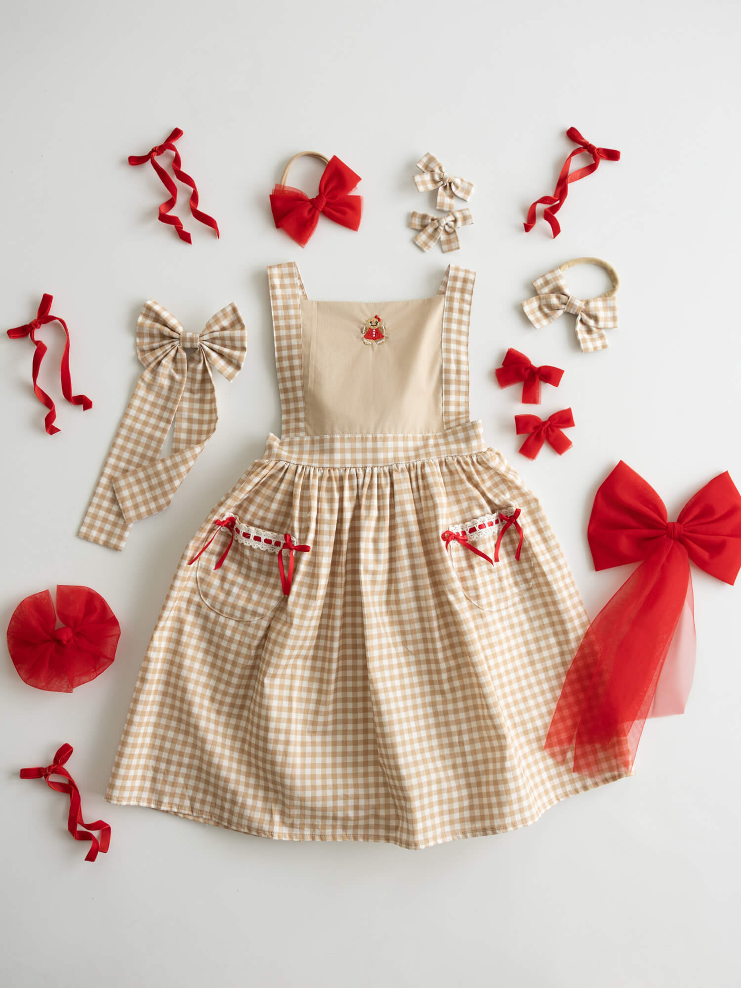Girls Christmas dress with Gingerbread embroidery and red bows.