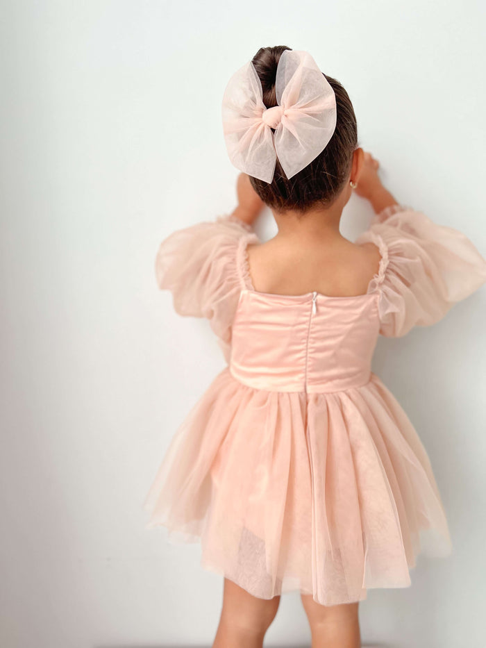 The back of our Eva champagne flower girl dress and matching champagne tulle bow hair clip.