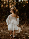 The back of our Eva tulle sleeve flower girl dress, worn by a young girl.
