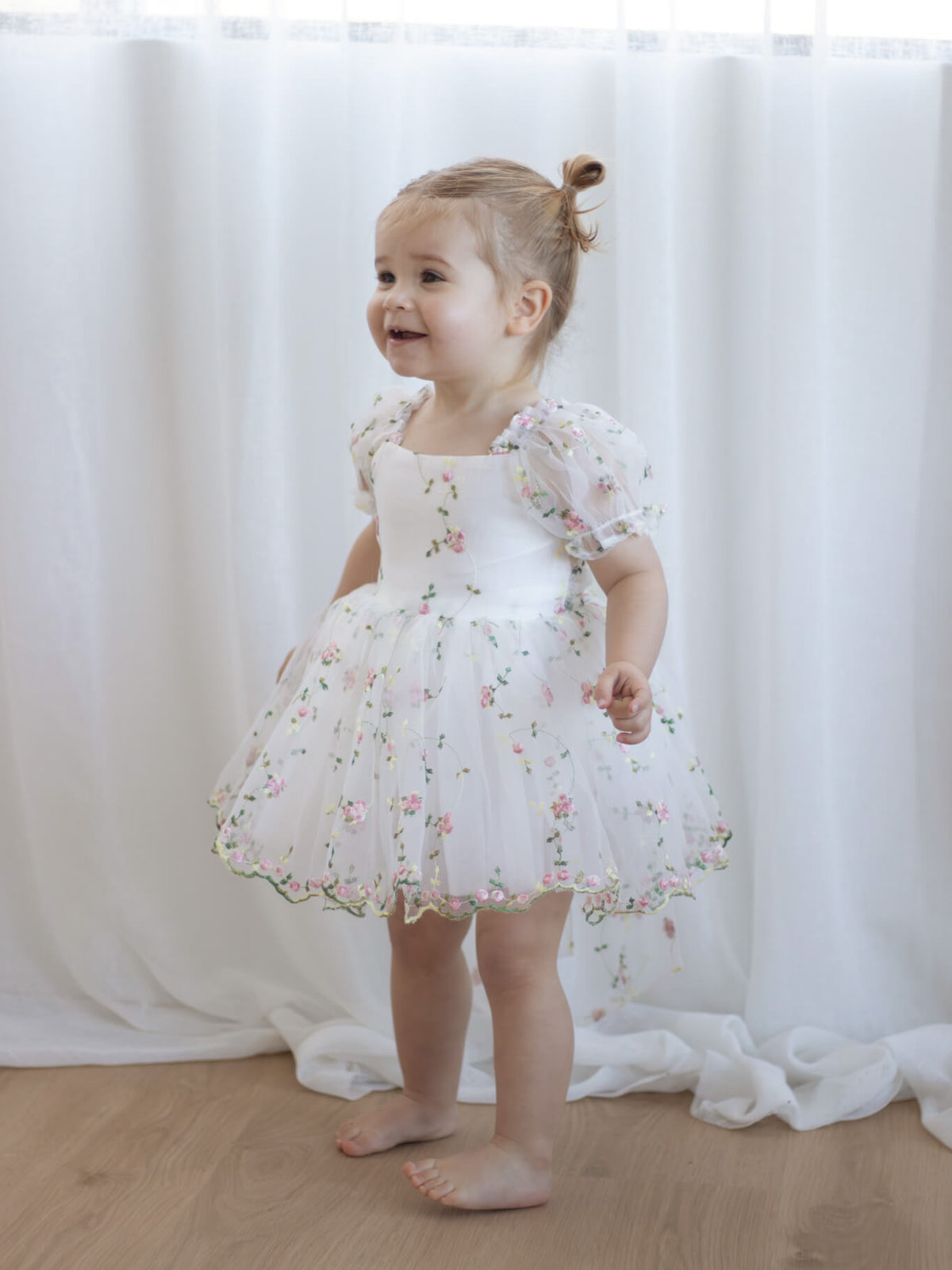 Fleur meadow flower girl romper dress is worn by a toddler.