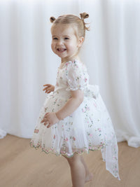 Fleur flower girl romper in Meadow, from the side, worn by a toddler.