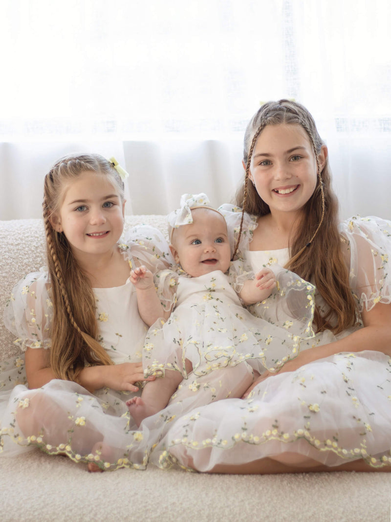 Three sisters wear our Fleur lemon blossom flower girl outfits.