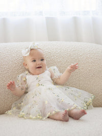 Fleur lemon blossom bow headband and Fleur lemon blossom flower girl romper is worn by a baby.