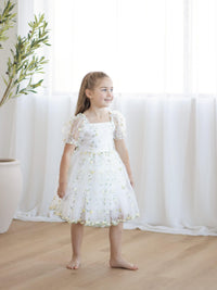 A little girl wears our ivory and lemon floral embroidered Fleur dress.