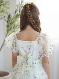 The back of our Fleur lemon yellow floral flower girl dress, showing the organza bow at the back.