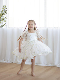 A little girl twirls wearing our Fleur lemon floral dress.