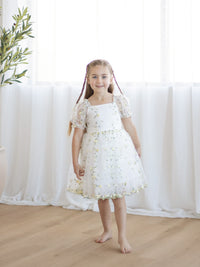 A little girl wears our Fleur lemon blossom floral organza dress.