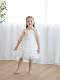 A little girl wears our Fleur flower girl dress in embroidered lemon floral organza.