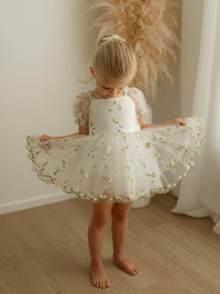 A little girl wears our Fleur lemon blossom yellow floral flower girl romper.