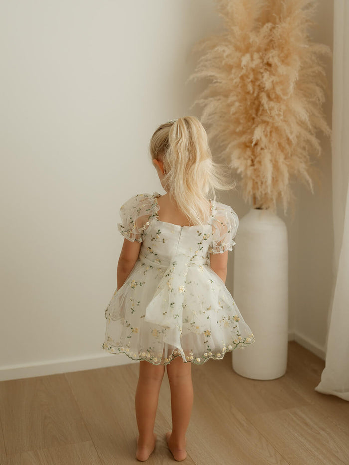 The back of our Fleur lemon blossom romper, a yellow floral organza flower girl romper.
