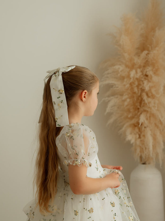 Fleur medium lemon blossom bow is worn by a young girl, along with our Fleur flower girl dress.